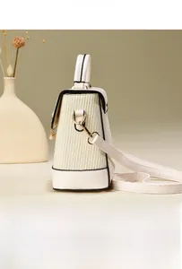 Détail du sac bandoulière crème avec texture plissée verticale et pendentif en perle