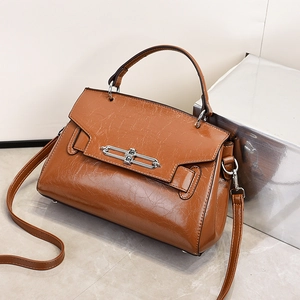 Caramel brown gloss patent leather top-handle handbag with silver buckle and shoulder strap