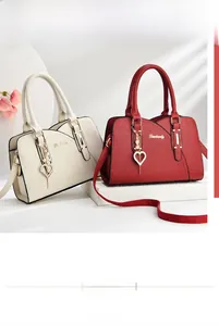Detail of beige and red textured leather handbags with gold hardware and pearl charms