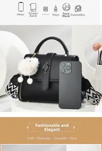 Détails du sac à main noir en cuir grainé avec sangle géométrique et pompon blanc