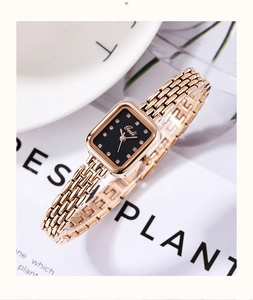 Détail d'une montre à cadran noir carré avec bracelet à maillons or rose poli