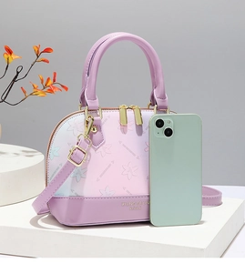 Detail of shell-shaped gradient handbag featuring floral texture and dual top handles