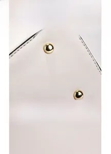 Détail du fond d'un sac blanc en cuir grainé avec des rivets de protection dorés
