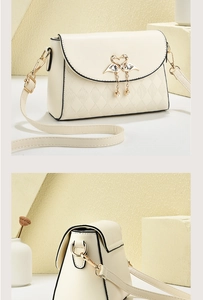 Detail of elegant cream shoulder bag with golden flamingo buckle and pearl accents