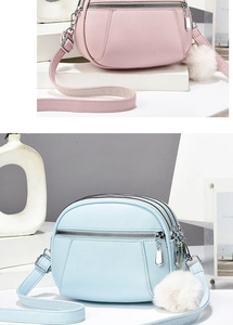 Detail of quilted leather crossbody bags with triple zipper layers and plush ball charms
