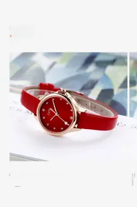 Detail shot of red leather strap watch with rose gold case on fashion magazine