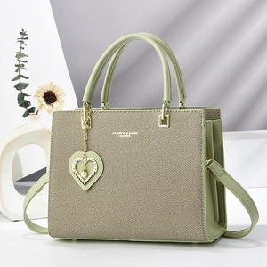Mint green woven leather tote bag with heart pendant and adjustable shoulder strap