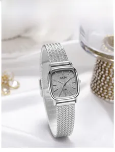 Macro detail of silver rectangular watch dial with sparkling texture and mesh strap