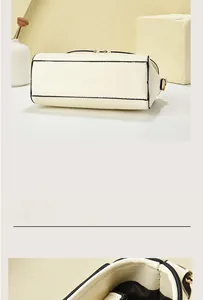 Detail view of cream white textured PU leather handbag with black piping and gold hardware