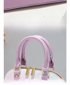 Detail of light purple handbag showing floral print, gold zippers and base piping
