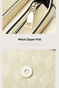 Detail of golden zipper puller and cross-grain leather texture on cream crossbody bag