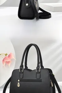 Close-up of black lychee grain texture and gold hardware on elegant handbag