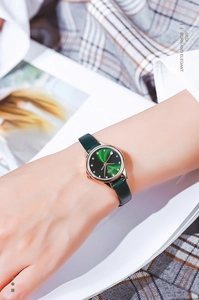 Close-up of GEDI watch with green sunray dial and rose gold case on woman's wrist