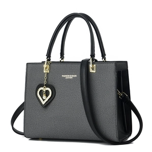 Structured black and grey tote bag with heart charm and fashion leather print