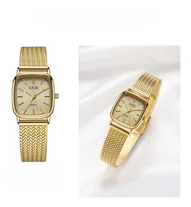 Macro detail of golden square quartz watch with textured dial and woven metal strap
