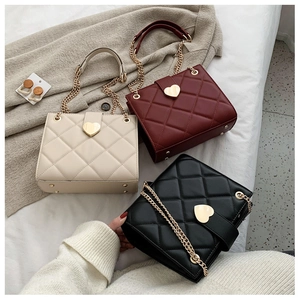 Close-up of quilted chain bags with heart locks in cream, burgundy, and black finishes