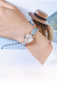 Detail of elegant ladies' watch featuring a rose gold case and slender grey leather strap
