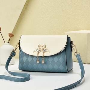 Elegant color-block quilted crossbody bag with gold swan buckle and pearl detail
