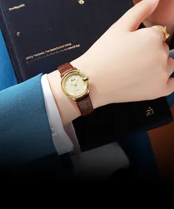 Detail of vintage gold quartz watch with brown leather strap worn by a female model