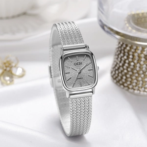 Elegant silver square quartz watch with textured dial and metal mesh strap on white silk
