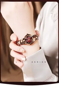 Gros plan d'une montre en or rose avec cadran rouge dégradé portée au poignet