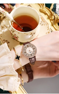 Détail de montre Gedi avec lunette en strass or rose et bracelet en cuir marron