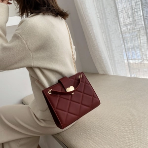 Chic burgundy quilted leather tote bag with a golden heart lock and chain strap