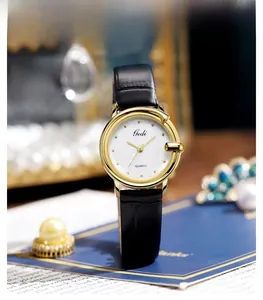 Close-up of elegant women's leather watch with textured dial and gold case on blue stand