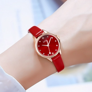 Elegant women's watch with red leather strap and rose gold case in a lifestyle shot