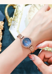 Close-up of Gedi rose gold watch with blue sunray dial and crystal bezel on wrist
