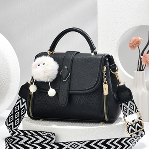 Mode Damenhandtasche aus schwarzem Leder mit gewebtem Gurt und Plüsch-Anhänger-Detail