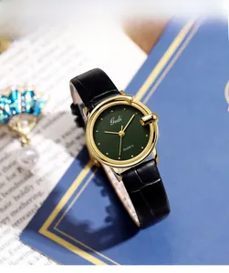 Macro view of gold round case with vintage green sunray dial and black leather strap