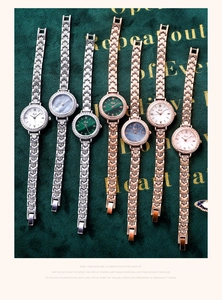 Macro detail of luxury Gedi quartz watches with rhinestone bezels on green velvet