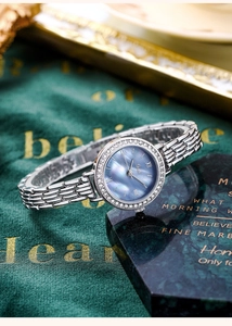 Close-up of a silver watch with rhinestone bezel and purple mother-of-pearl dial