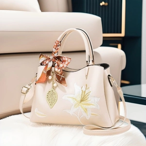 Elegant cream embroidered handbag with lily floral patterns and decorative silk scarf wrap