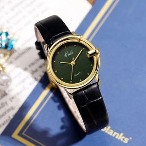 Gedi vintage ladies quartz watch with dark green dial and black leather strap on books