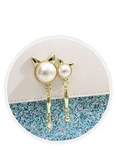 Detail of cat-shaped gold hardware with pearls on a white and blue sequin handbag