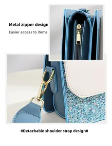 Detail view of light blue glitter handbag showing gold zipper and detachable strap hooks