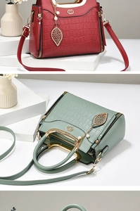 Close-up of crocodile texture handbag with gold handles and pearl leaf pendant details