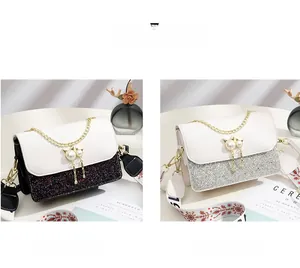 Detail of glitter crossbody bags in black and white with ethnic style embroidered straps