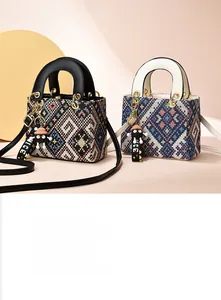 Detailed embroidery texture on ethnic style tote bag with gold ring hardware and charm