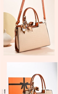 Chic beige textured handbag with brown leather straps and orange gift box packaging