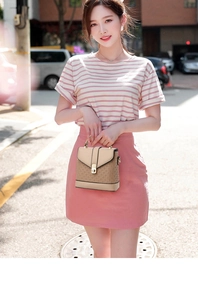 Detail of a chic beige handbag with metallic buckle and textured pattern on the street