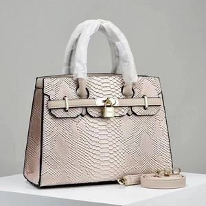 Detail of light beige snakeskin textured handbag with gold padlock and detachable strap