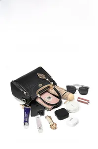 Flat lay showing large capacity interior of black crocodile embossed handbag with daily essentials