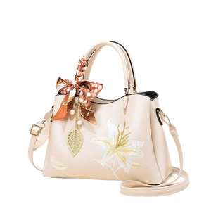 Elegant beige embroidered handbag with floral patterns and a decorative silk scarf