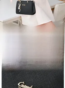 Détail du sac à main en cuir noir avec ferrures dorées et breloque nœud en perles