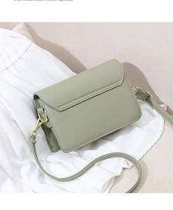 Detail of light green faux leather shoulder bag with gold hardware and fine stitching