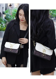 Detail of sequin crossbody bag with cat pearl lock and golden chain strap