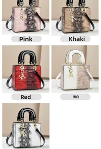Details der Handtaschen-Kollektion mit Krokodil-Prägung und V-förmigen Metall-Anhängern